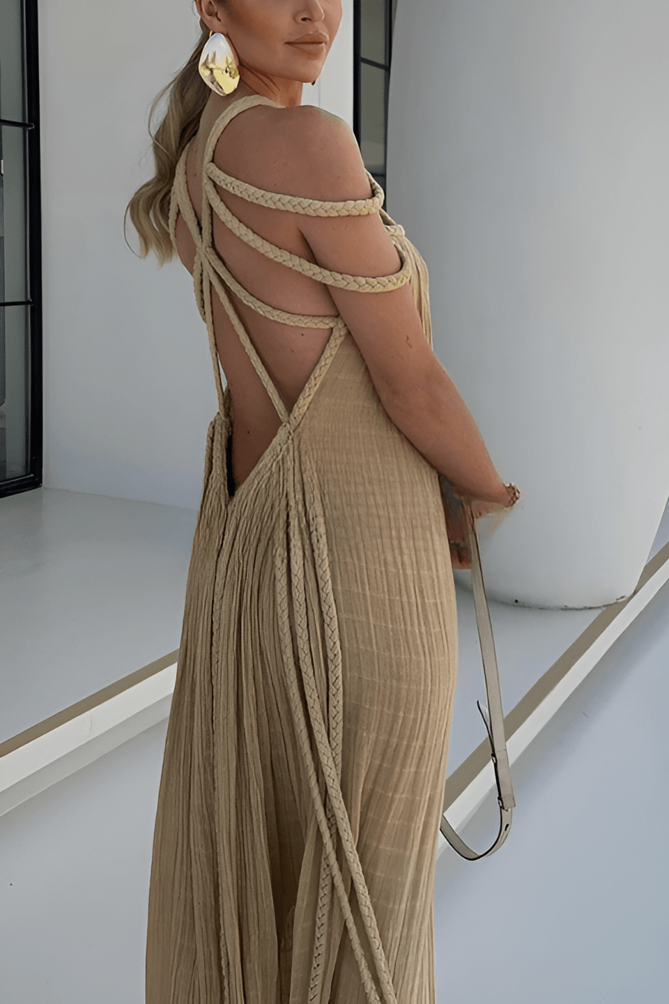 Long pleated dress with cord detailing and an artistic neckline