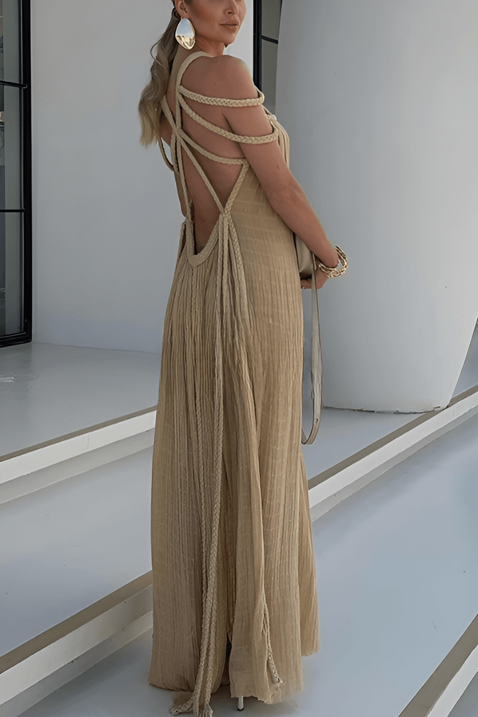Long pleated dress with cord detailing and an artistic neckline