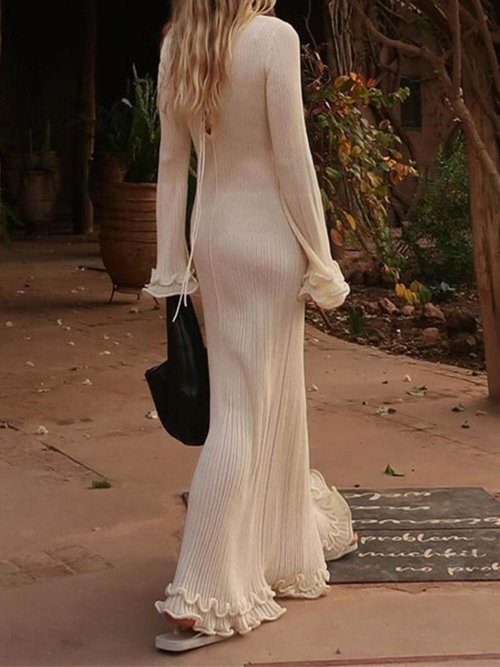 Elegant knitted maxi dress with trumpet sleeves, folded hem, and a round neckline